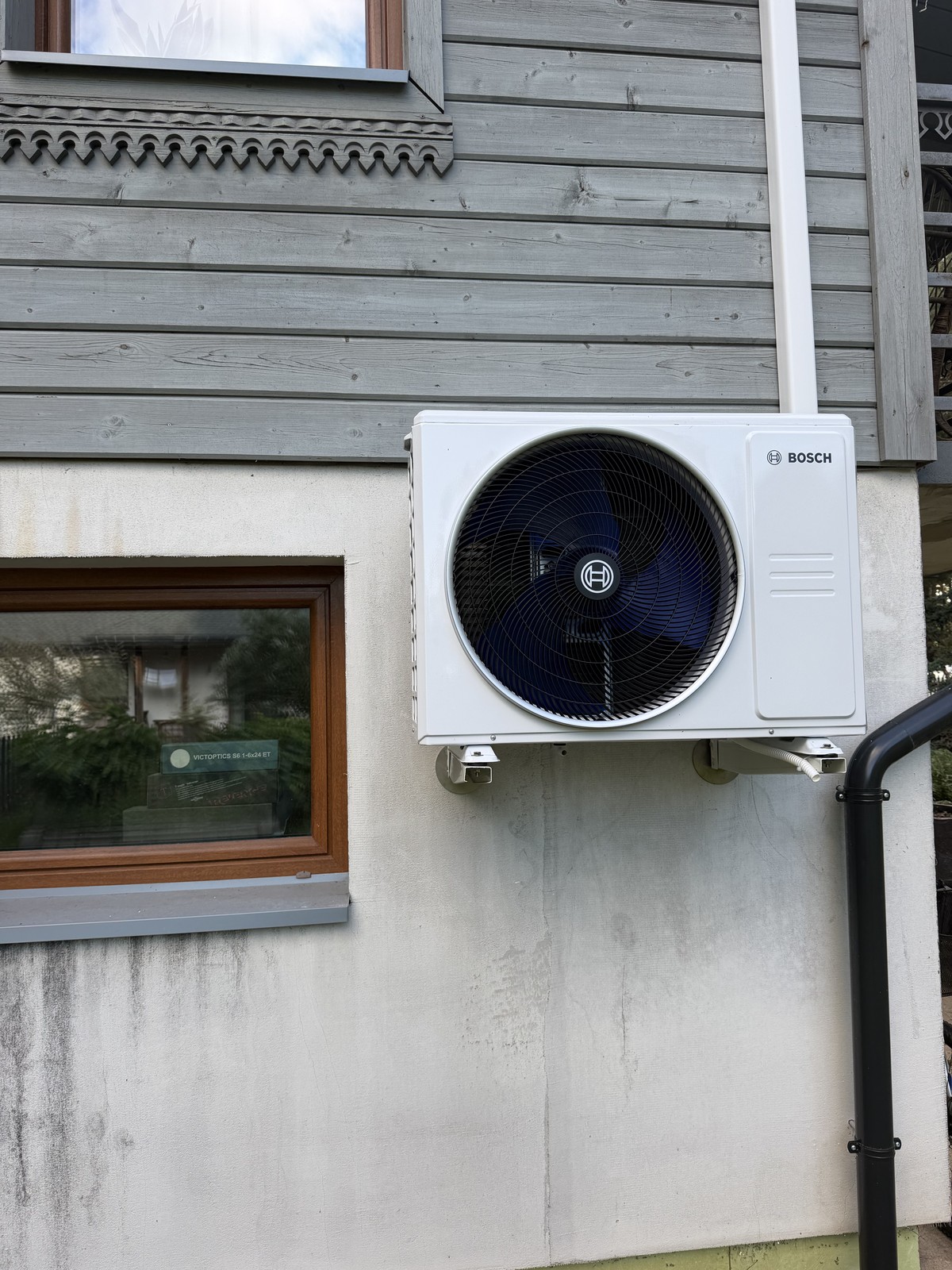 Jednostka zewnętrzna klimatyzacji Bosch na elewacji drewnianego domu – GMK Instalacje